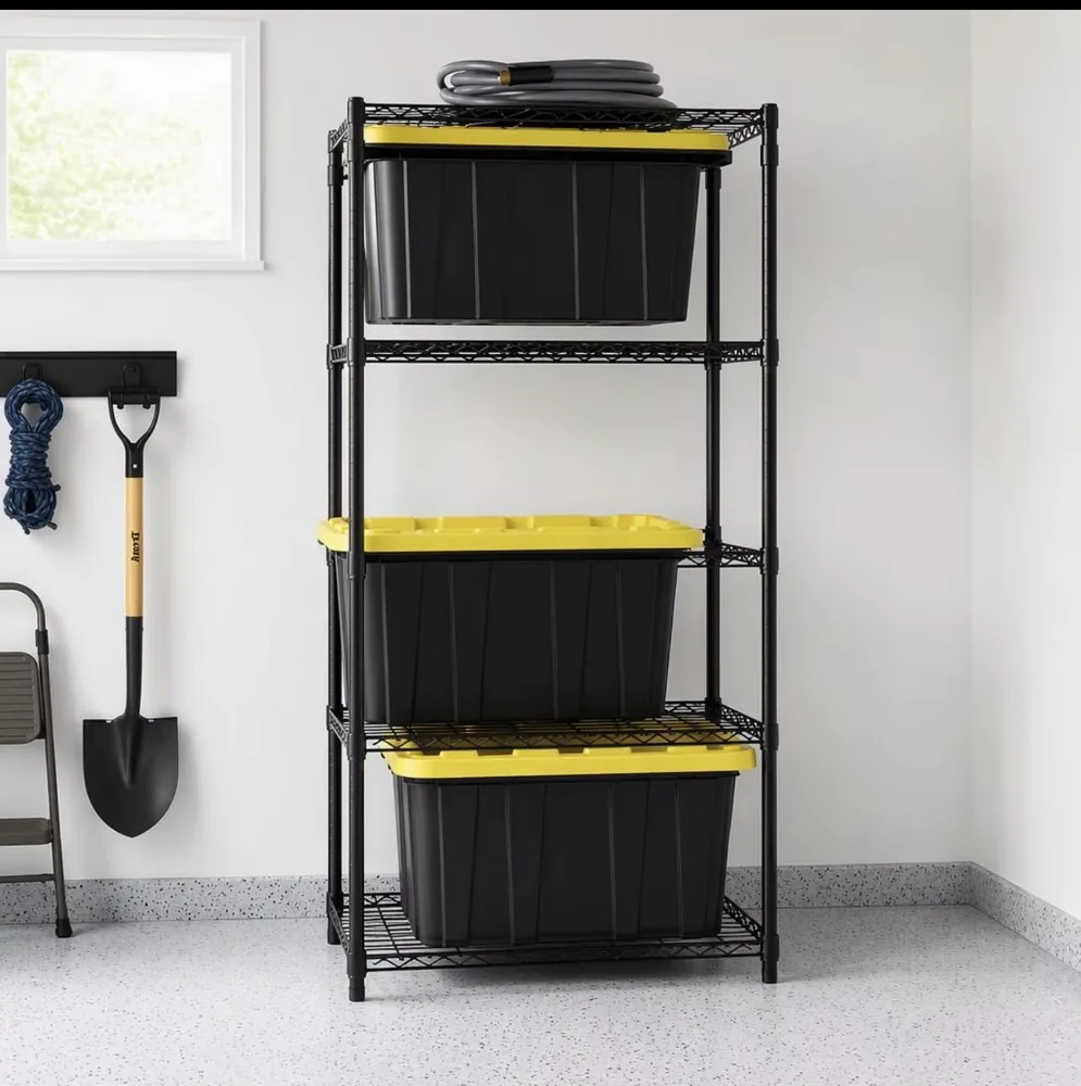Black wire shelving unit in a garage holding three black totes with yellow lids